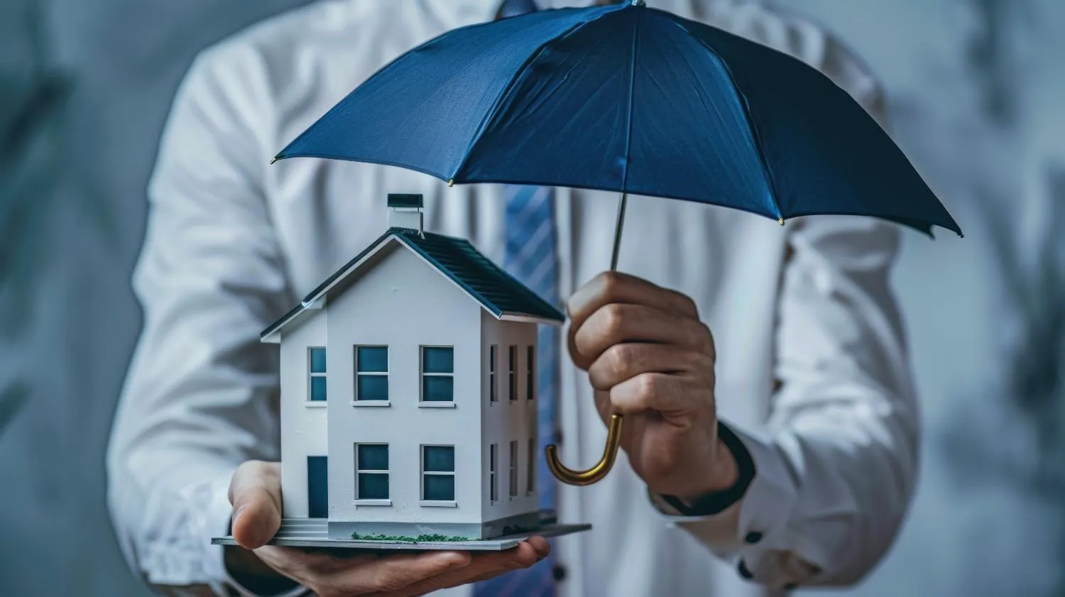 Model house held under an open umbrella